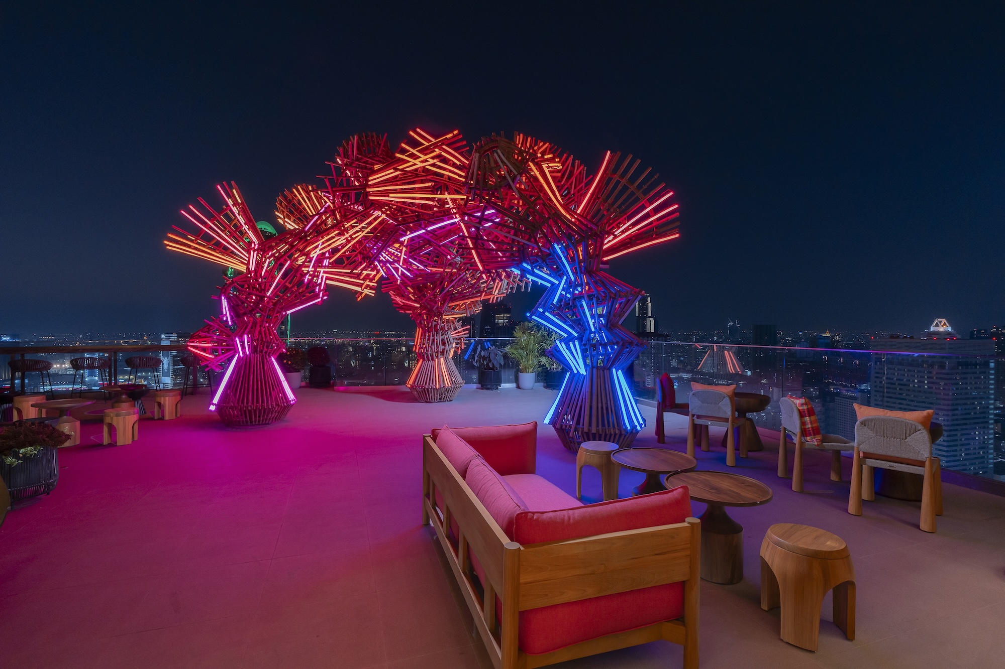 Bamboo arch glowing in neon at Sato San Rooftop Bar